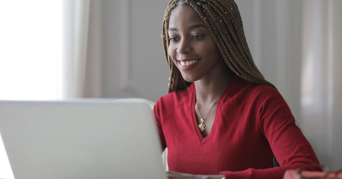 Escritor sorrindo, olhando para o laptop