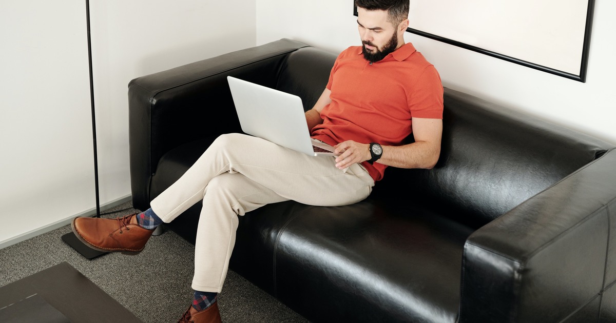 Escritor sentado em um sofá com laptop