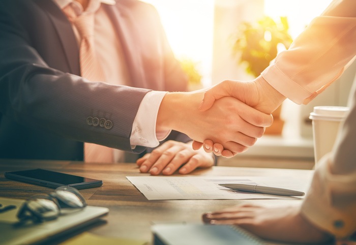 Close-up of business man and woman shaking hands