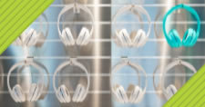 rows of white headphones with one teal pair of headphones