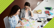 two businesswomen working together at a table with paperwork