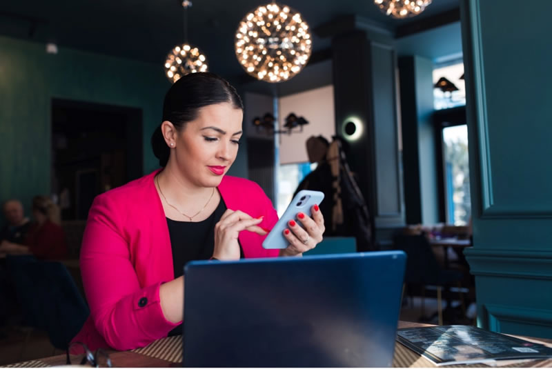 Professional writer in cafe with cellphone and laptop