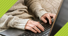 closeup of a woman's hands typing on laptop keyboard
