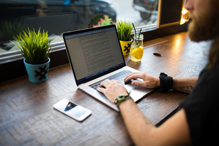 Copywriter working on his laptop at a cafe